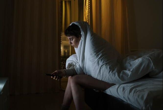 Insomniac woman in bed sheets, sleep disturbances, bad quality of sleep 