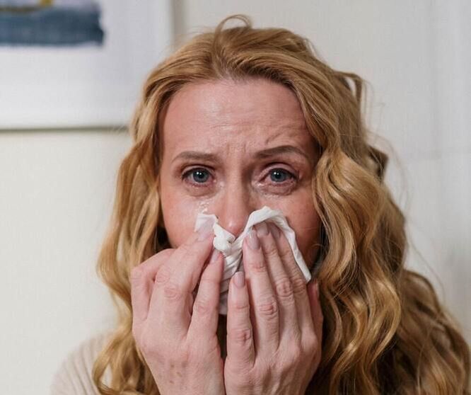 Woman sneezing with allergies, seasonal allergies, or asthma