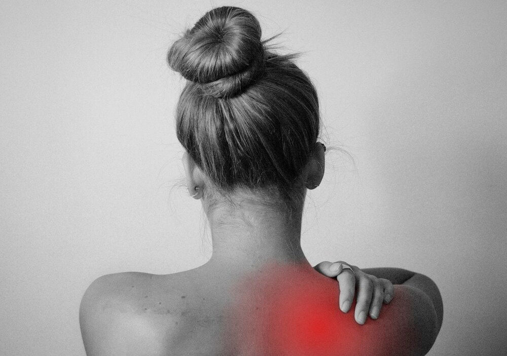 Woman holding her shoulder, neck pain, whiplash or shoulder pain